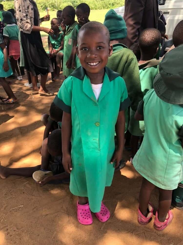 Girl in school uniform with donated shoes